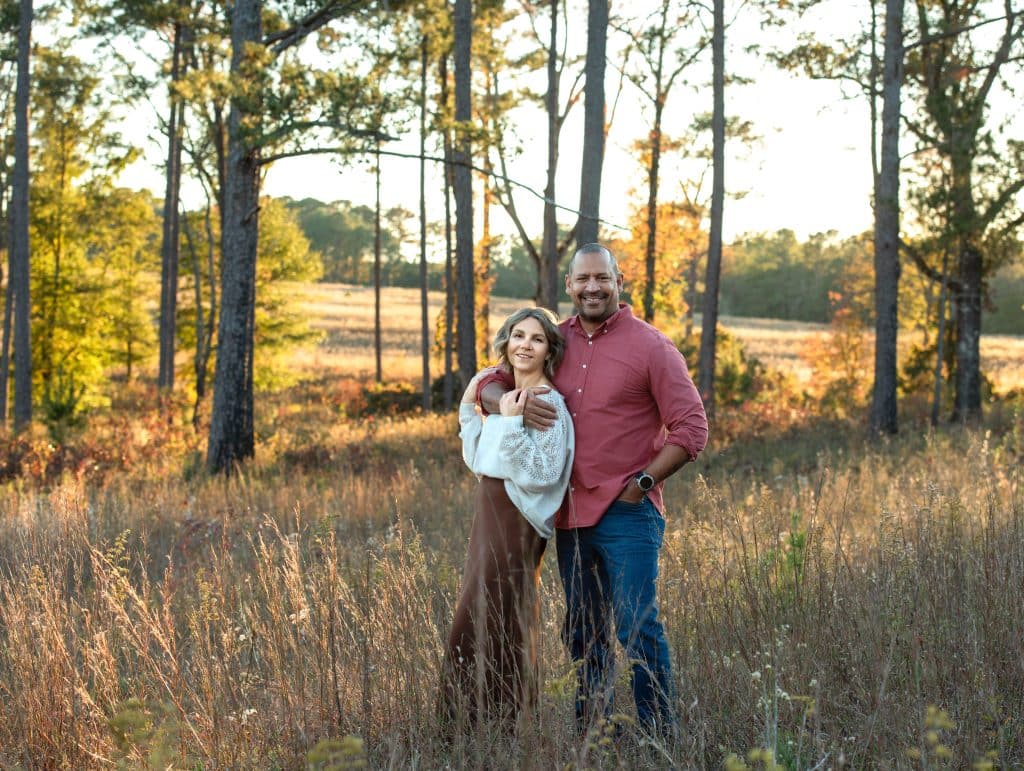 A couple during their couple photosession standing in a wheat field at golden hour at Callaway Gardens, Ga. 