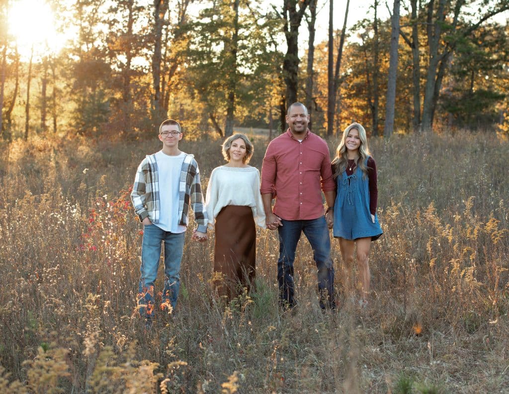 A family during their family photo session in Columbus Ga standing holding hands during golden hour.