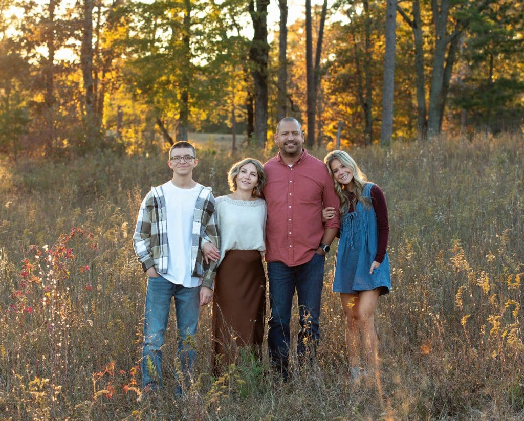 A family during their photography session at Callaway Gardens standing in a wheat field at golden hour